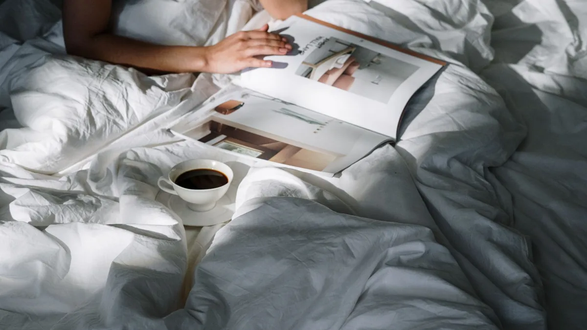 Relaxing morning in bed with a cup of coffee and a magazine to read