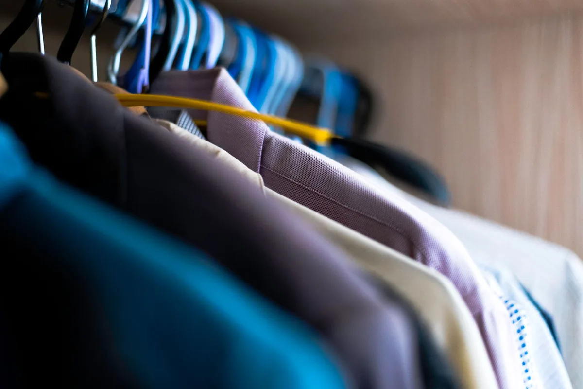 Close-up of shirts on hangers on a closet rod