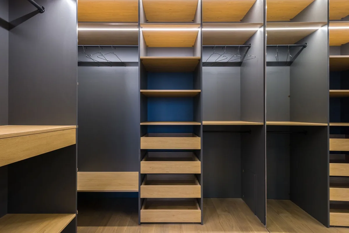 Dark grey and oak closet units with lit shelves, open hanging sections and stacked shelves